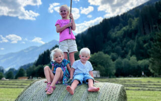 Kinder auf Heuballen am Peternhof in Klausen bei Kirchberg in Tirol